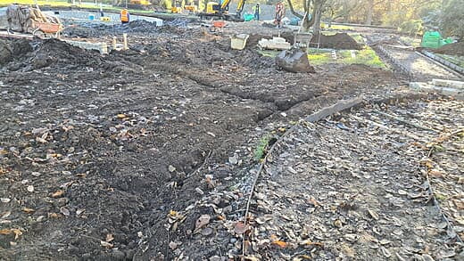 Trenches backfilled with irrigation pipes near the path edge