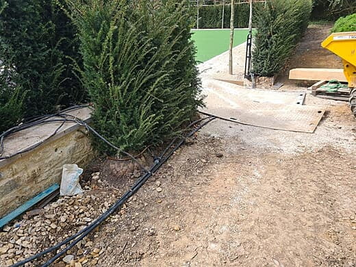 Irrigation feeds and dripline around a hedge before topsoil laid